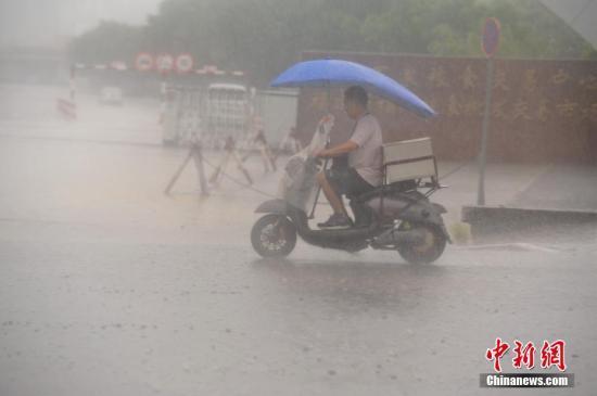 7月31日，暴雨侵袭福州，市民艰难出行。中新社记者 王东明 摄