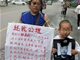 丈夫被拘派出所身亡 内蒙古一母子街头举牌讨公道